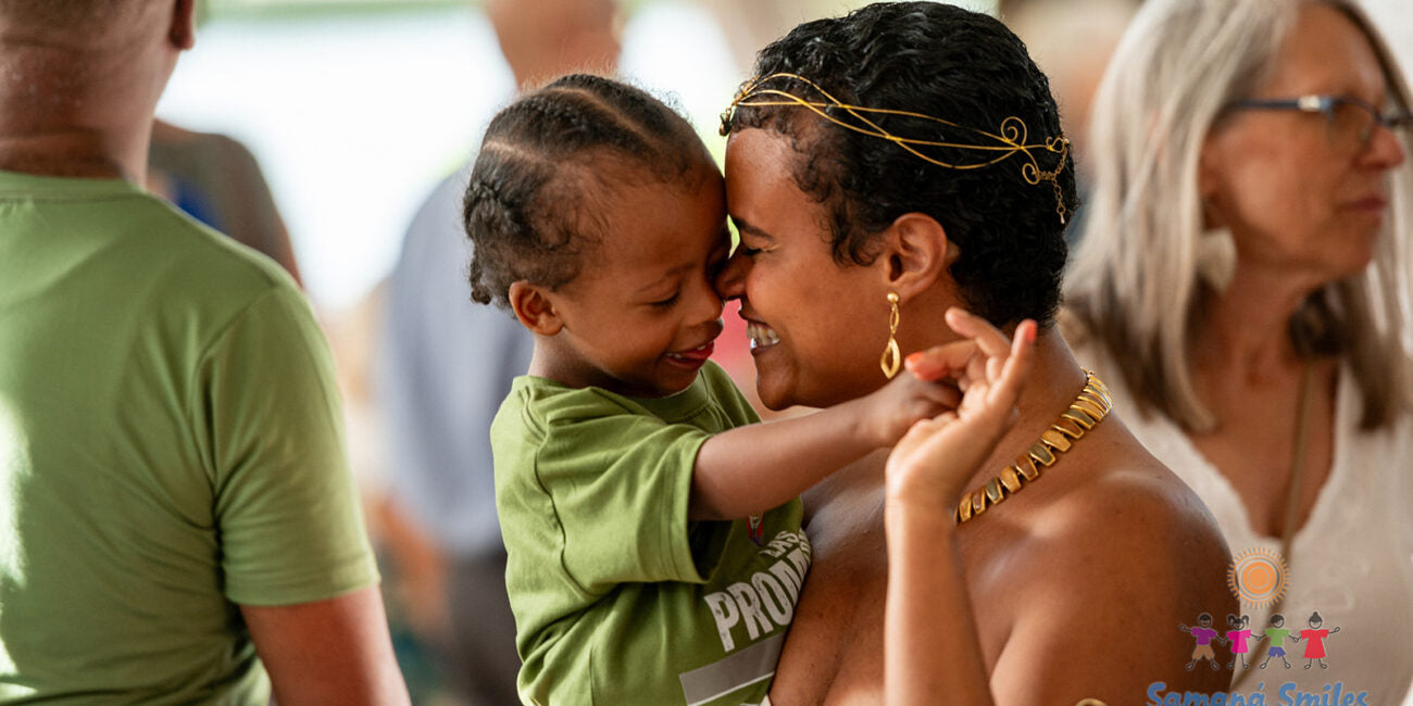 Woman and child embracing with a blurred background of people