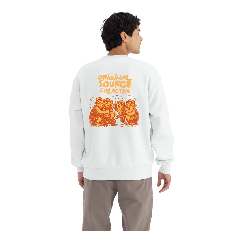 Person wearing a white sweatshirt with orange animal graphics and Original Source Collective text on the back